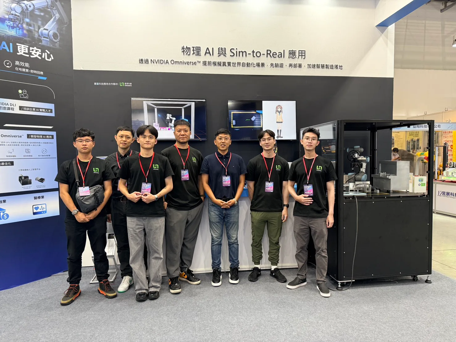優那科創團隊於 2026 台北國際自動化工業大展攤位前合影,背後主視覺牆寫著「物理 AI 與 Sim-to-Real 應用」與 NVIDIA Omniverse 模擬說明,右側為玻璃防護罩內的協作型機器手臂實機